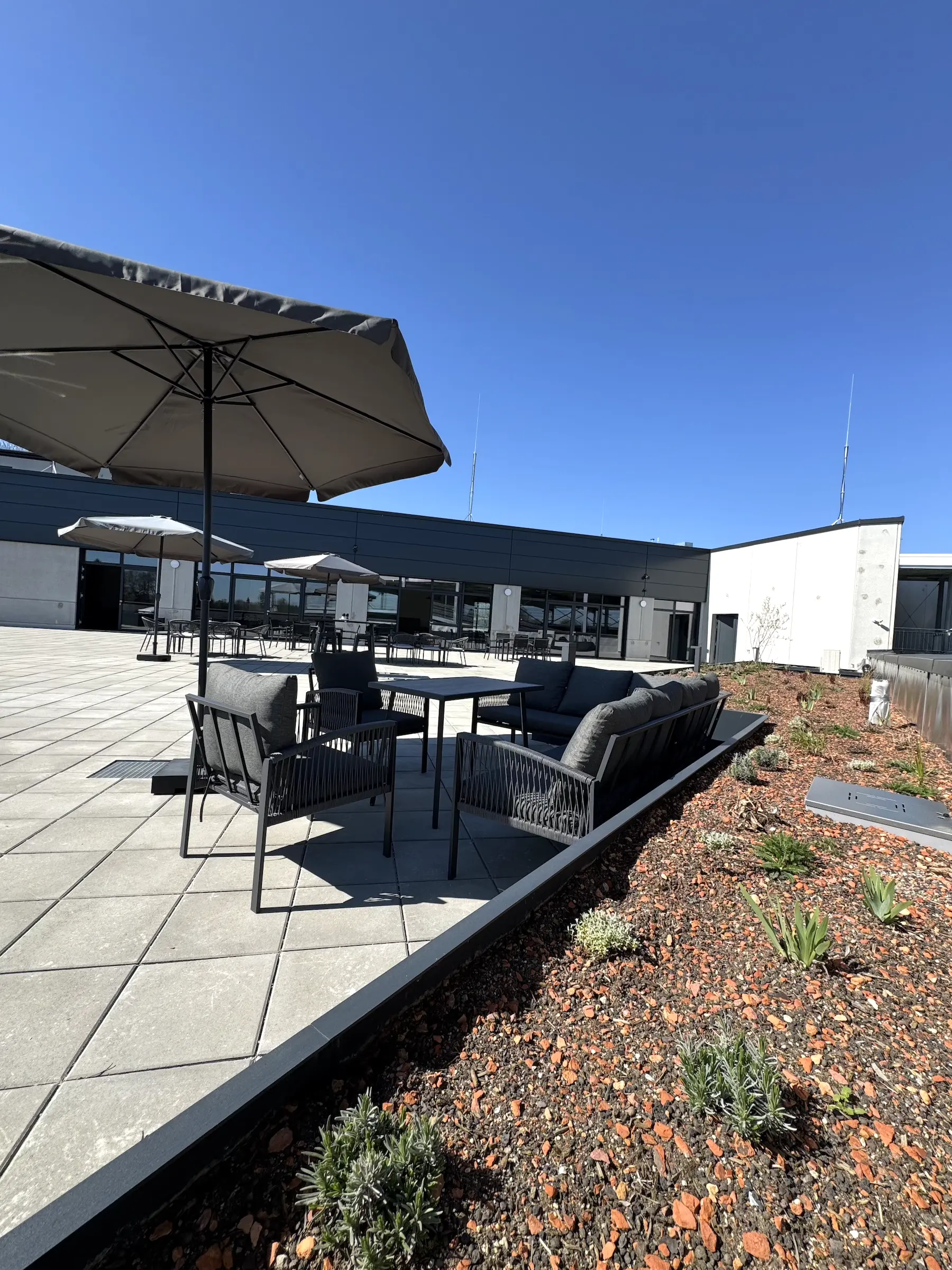 MD-Genusswelt-Rosenheim-Dachterrasse-5 Sonnenschirm und Möbel auf der Dachterrasse der M&D Genusswelt, der öffentlichen Kantine in Rosenheim und Raubling