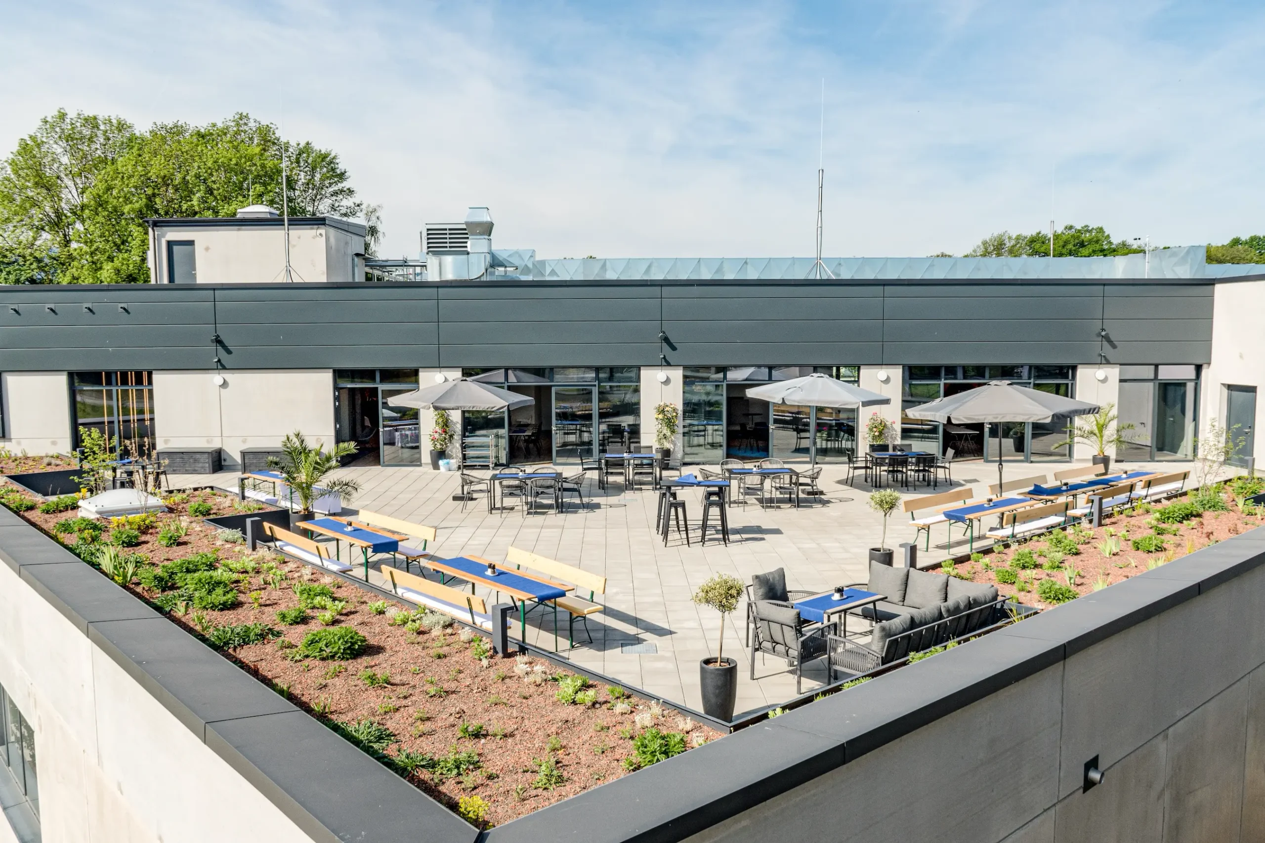 Die Dachterrasse der M&D Genusswelt in Rosenheim vorbereitet für eine Feier mit Bergblick